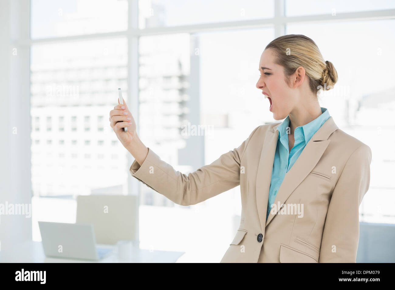 Attractive young businesswoman looking shocked at her smartphone Stock Photo