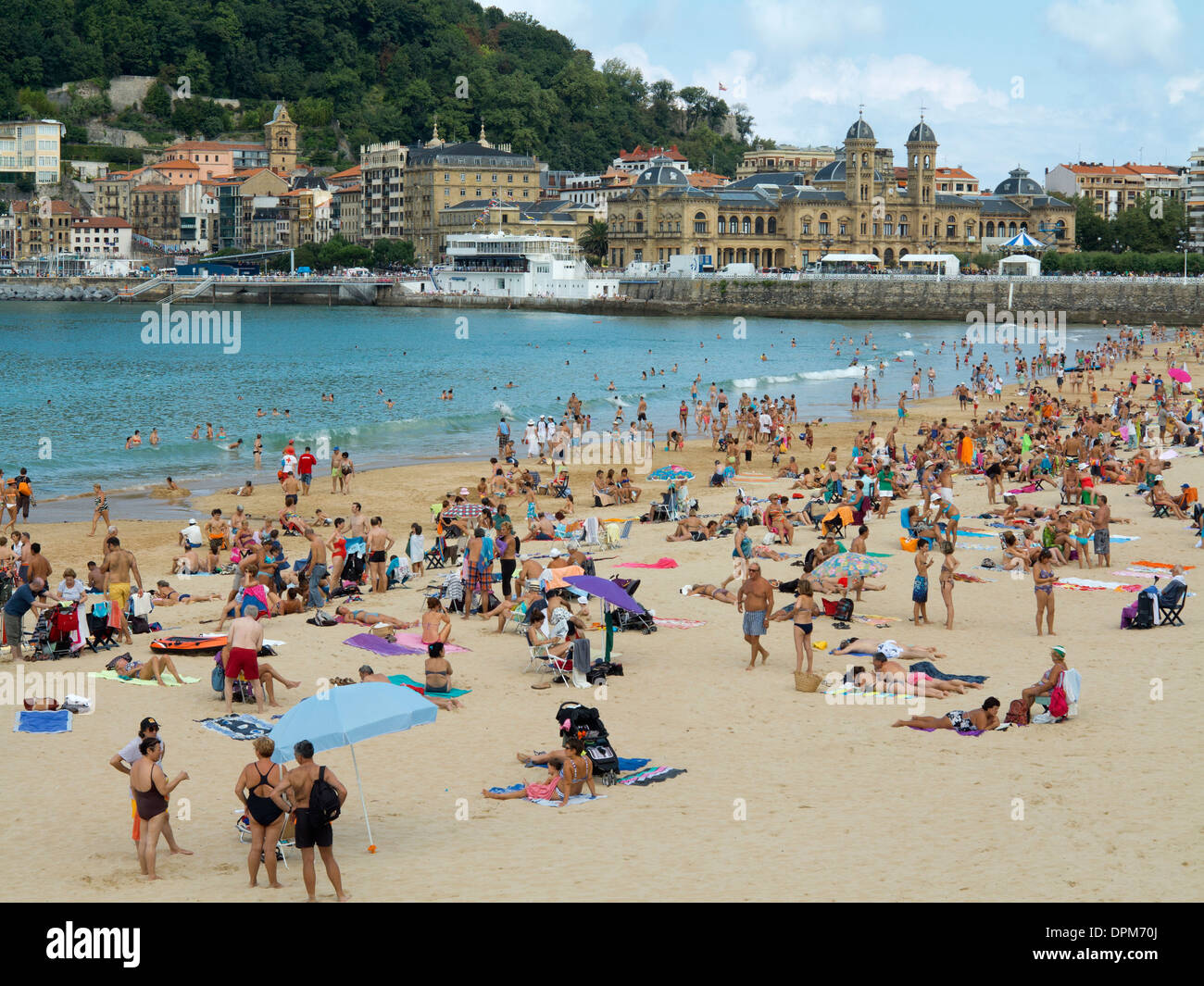 Families, swimmers and sunbathers relaxing at the weekend on La Concha beach, San Sebastian