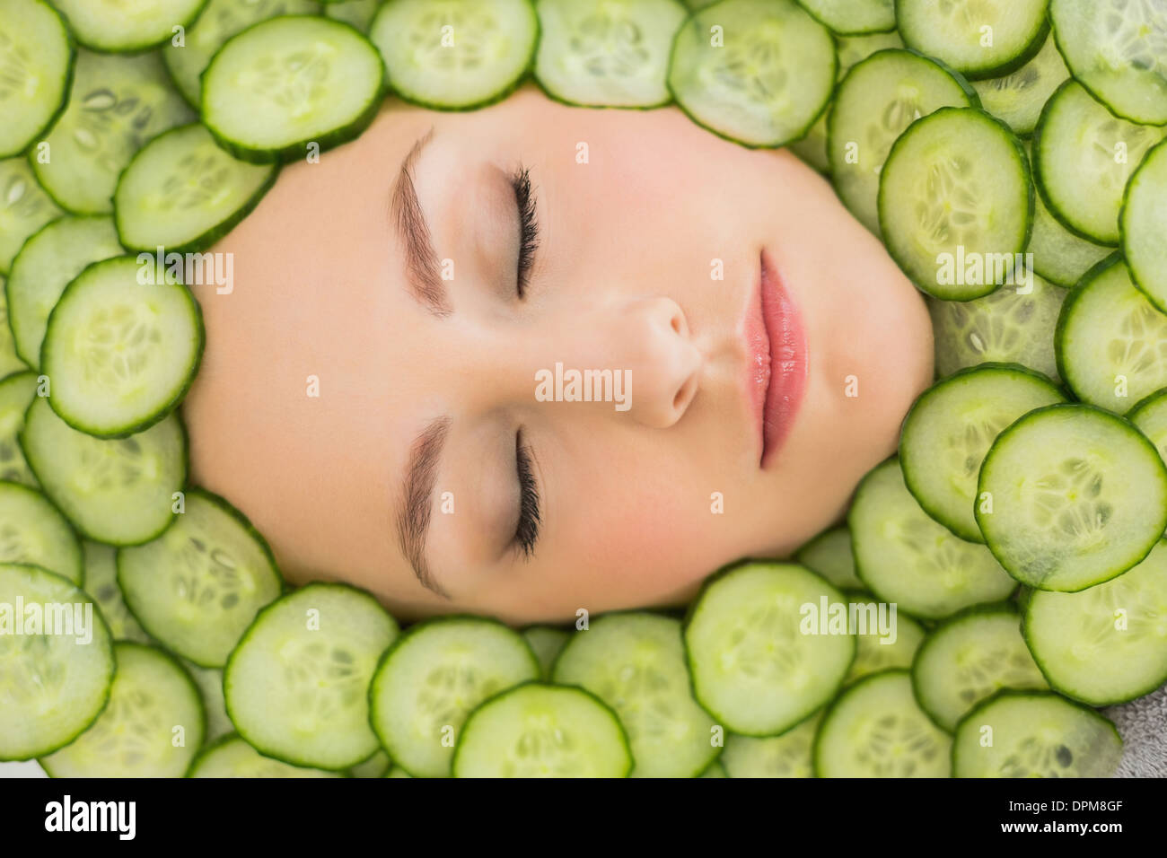 Beautiful woman with facial mask of cucumber slices on face Stock Photo
