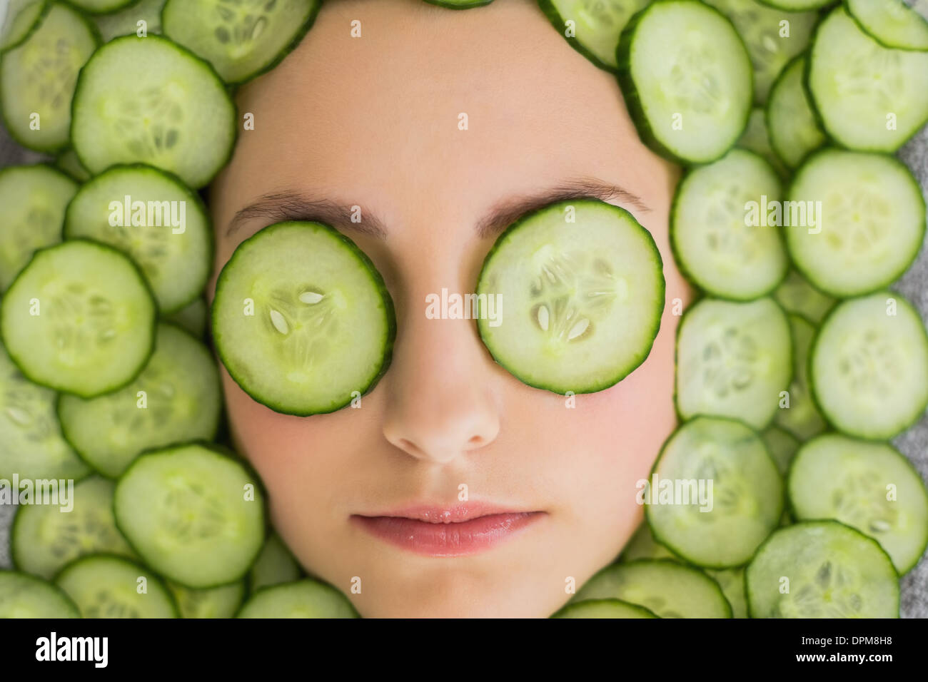Beautiful woman with facial mask of cucumber slices on face Stock Photo
