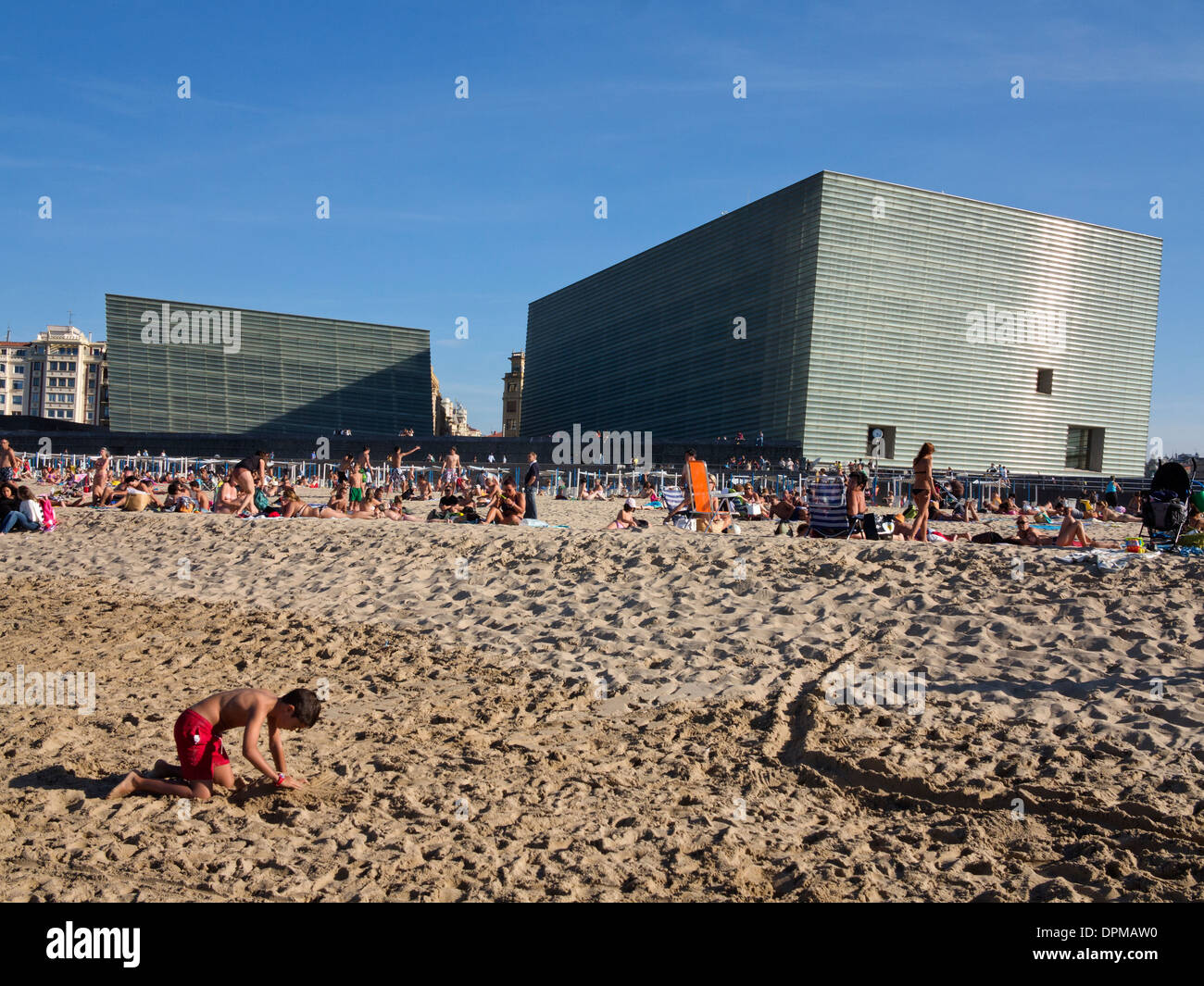 Sunbathers and swimmers on Zurriola beach with Kursaal congress centre and auditorium in background, San Sebastian (Donostia), Spain Stock Photo