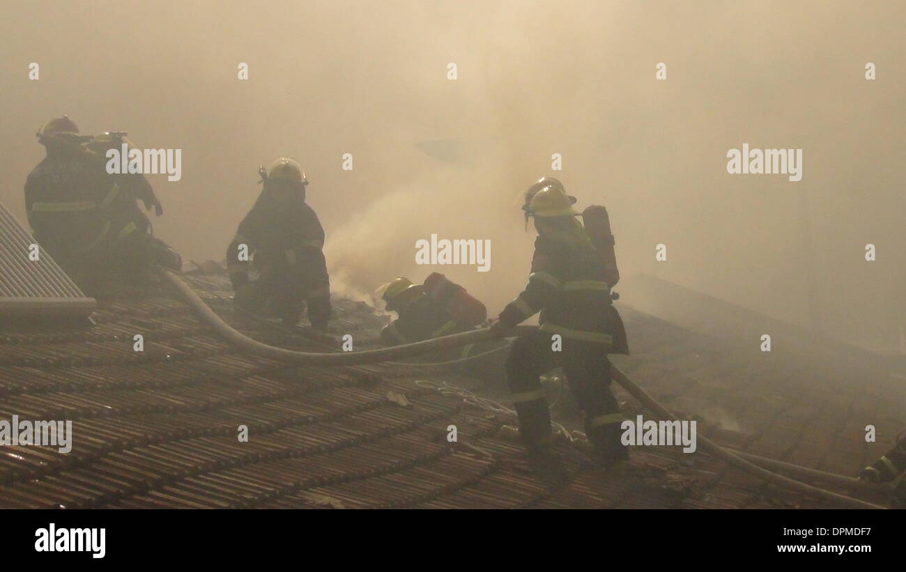 Nanjing, China's Jiangsu Province. 15th Jan, 2014. Fire fighters spray water to a burnt house on Xinglong Street, Nanjing, capital of east China's Jiangsu Province, Jan. 15, 2014. The fire broke out in the house on Wednesday and consumed an area of some 300 square meters. Two bodies were found dead in the accident. Credit:  Wang Wei/Xinhua/Alamy Live News Stock Photo