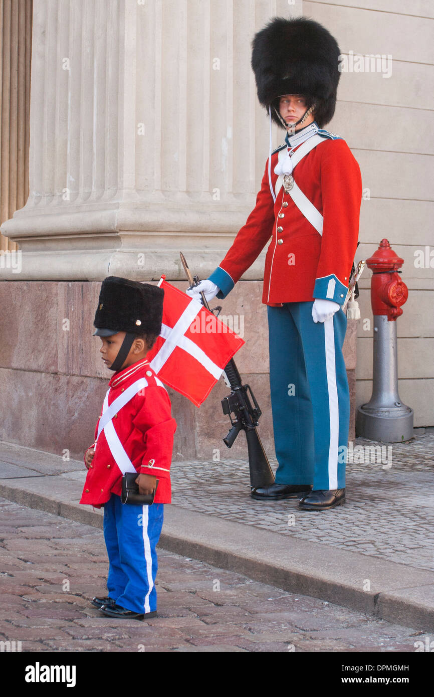 Royal guard on duty at Amalienborg Palace and child dressed up as Royal guard on the Queen's Birthday, Copenhagen, Denmark Stock Photo