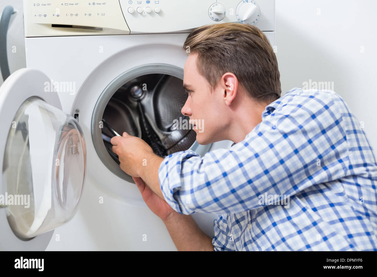 Technician repairing a washing machine Stock Photo Alamy