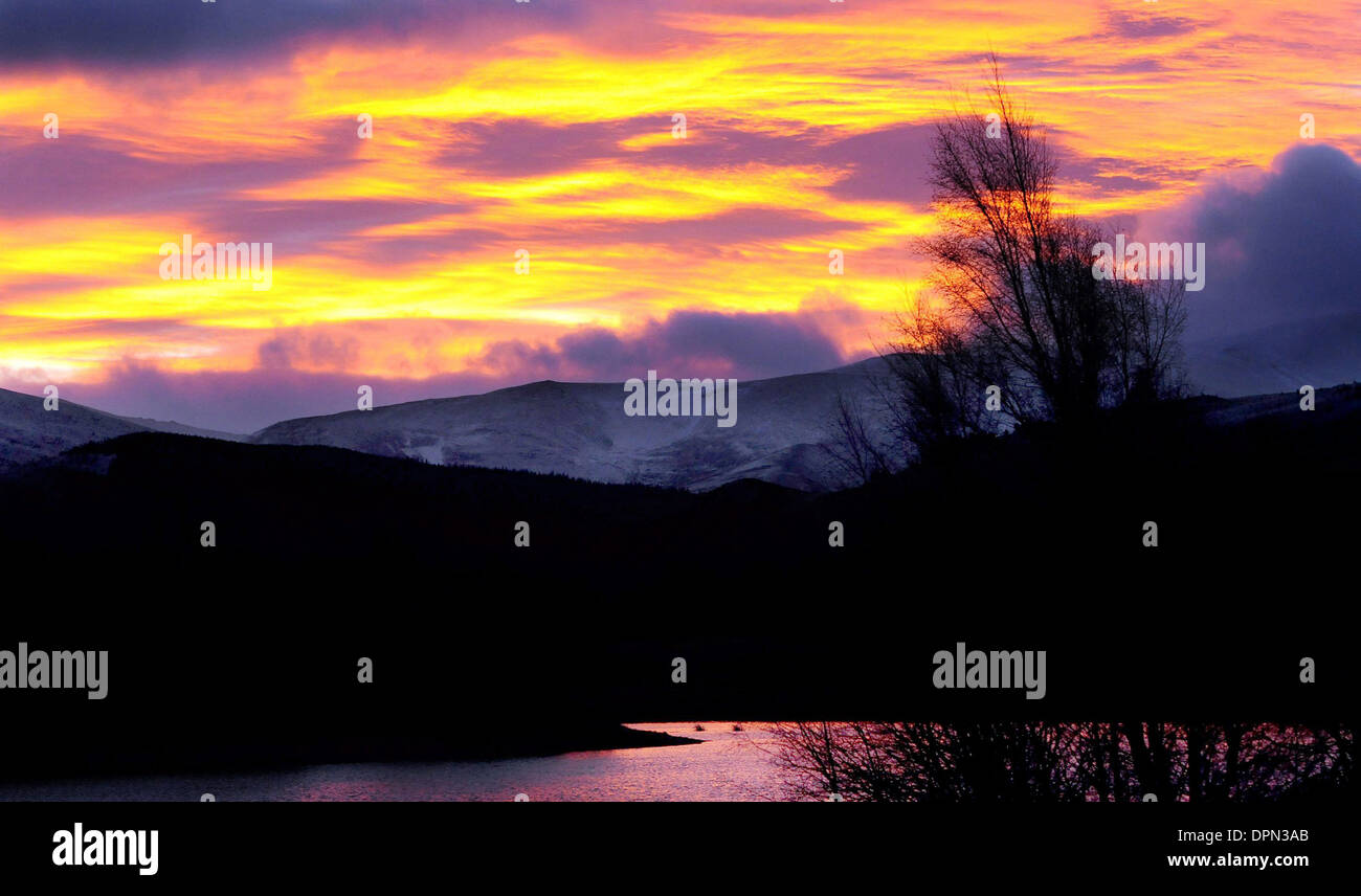 The sun rises this morning over snow covered mountain tops near Aviemore Stock Photo