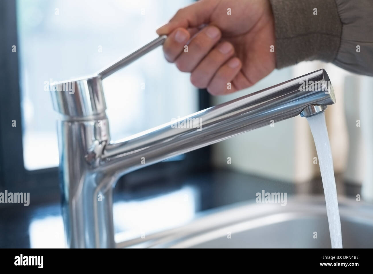 Plumbers hand opening a water tap at bathroom Stock Photo Alamy
