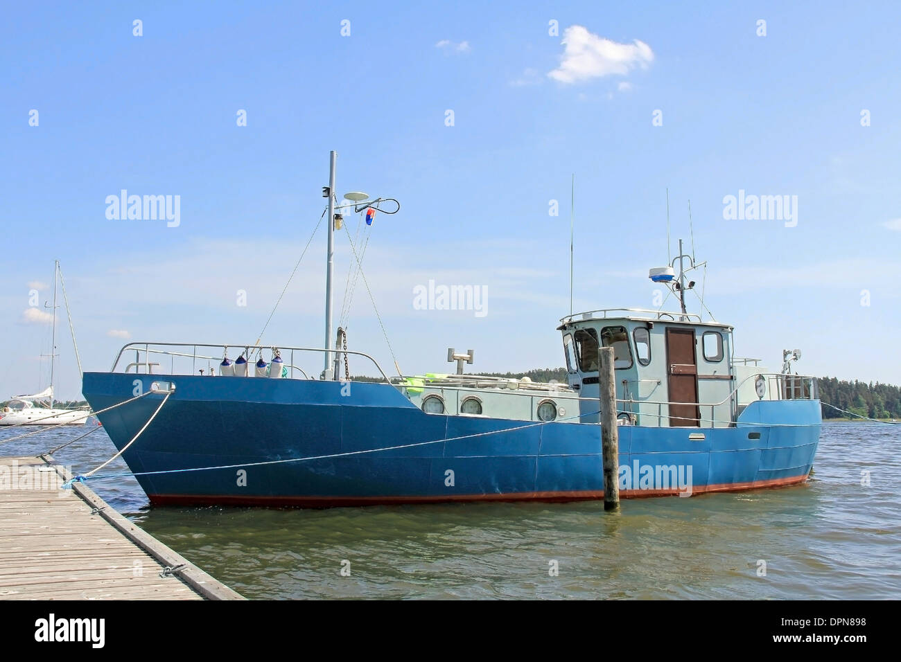 Blue fishing boat or fishing trawler in a marina at summer. Stock Photo