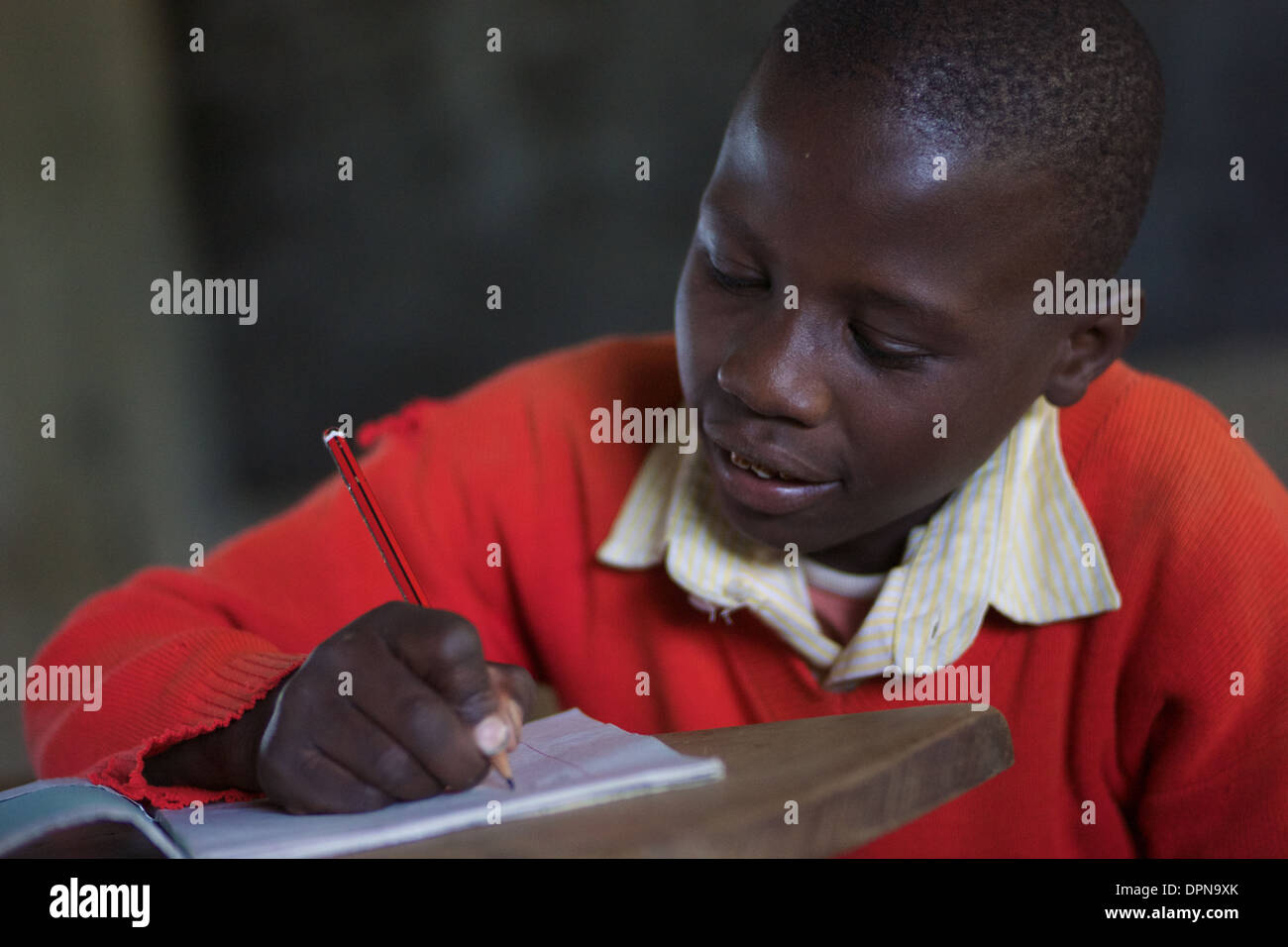 Primary age boy writing in exercise book at Rubiri Primary School Naivasha, Kenya Stock Photo