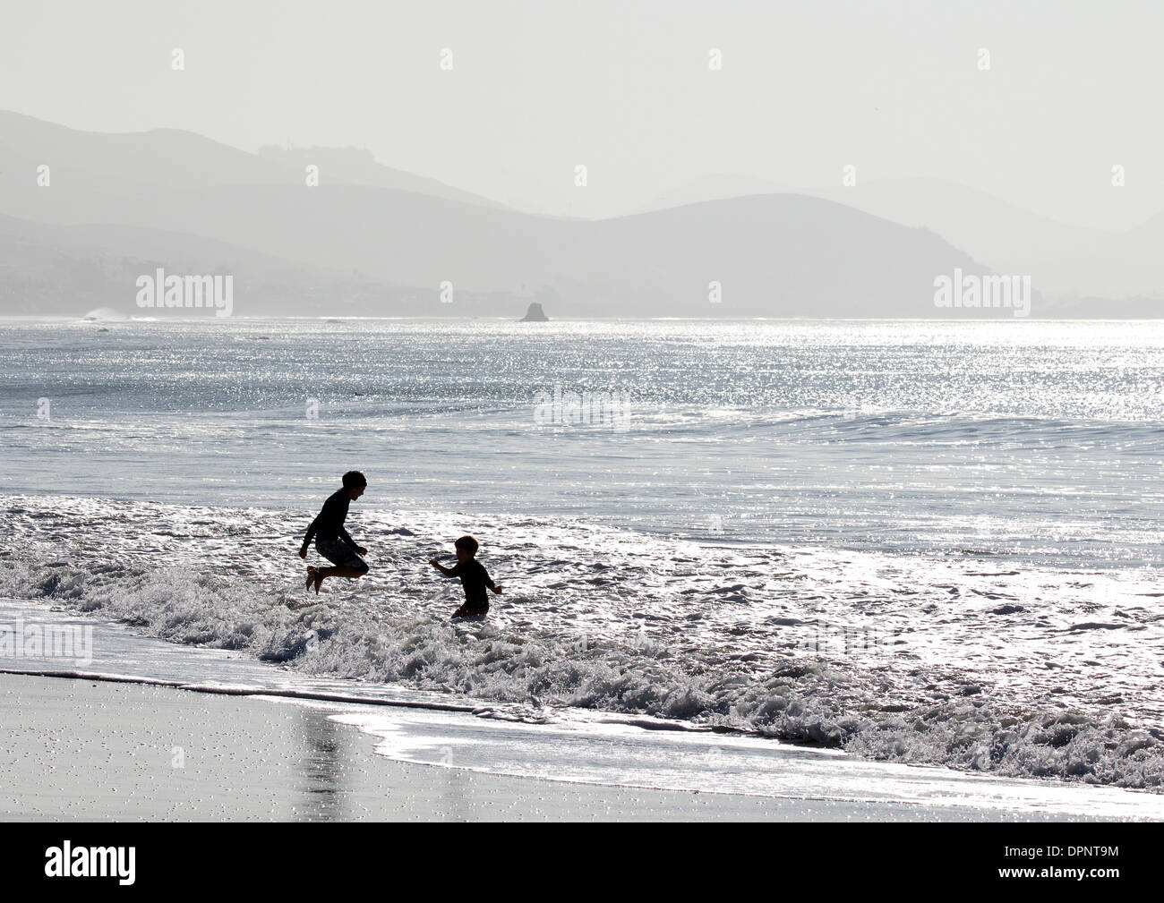 Two Young Boys Playing in the Surf Stock Photo - Alamy