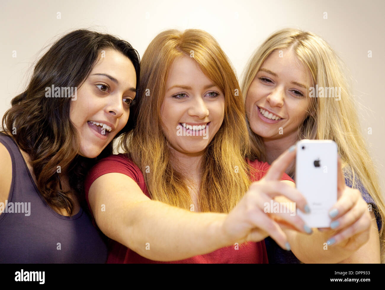 Selfie, being taken by three young women teenagers teens girls on an Apple iPhone, Essex UK Stock Photo