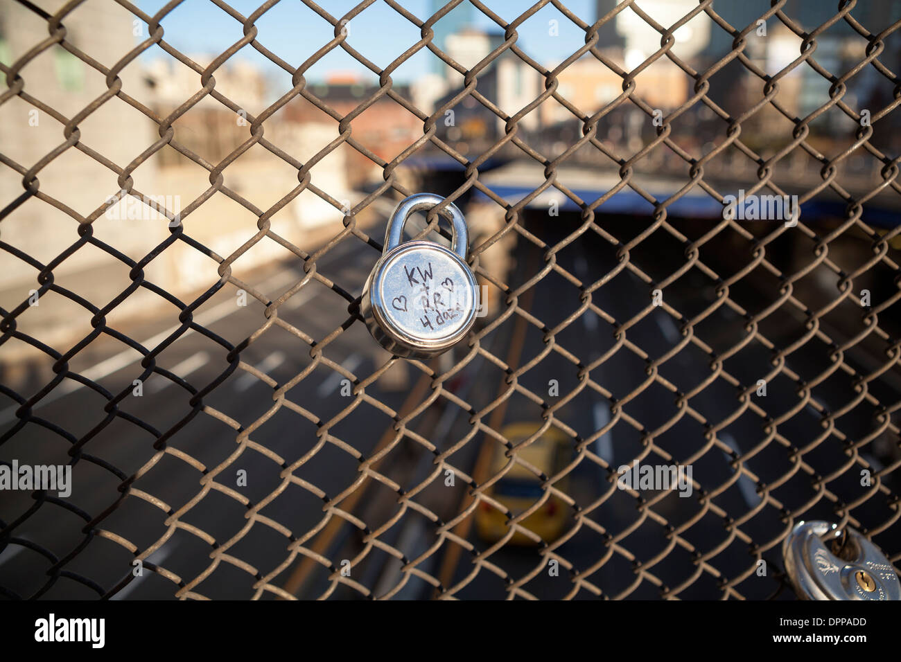 A love lock with two people's initials and heart symbols is attached to a fence in Boston. Stock Photo
