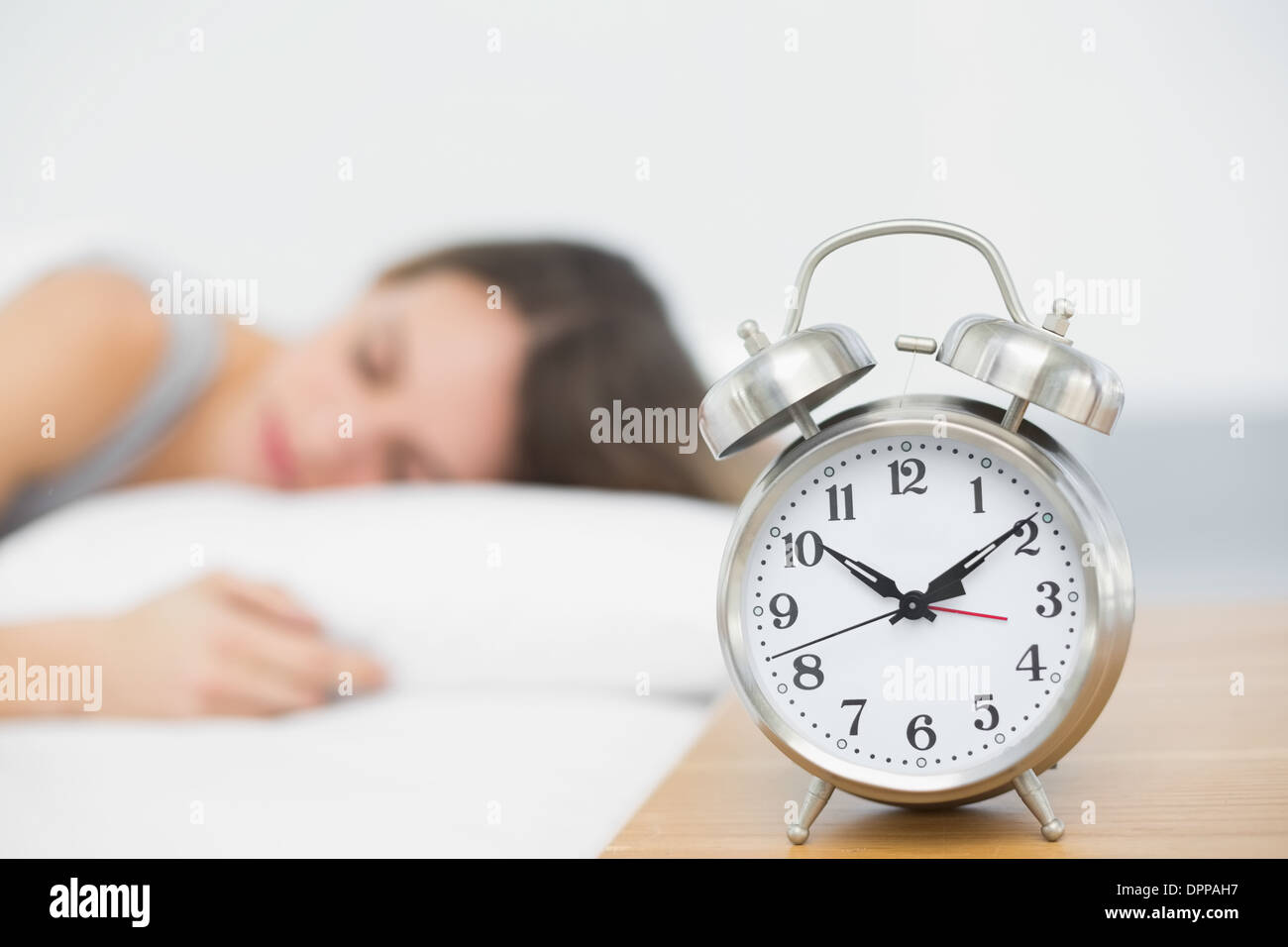 Retro alarm clock standing on bedside table Stock Photo