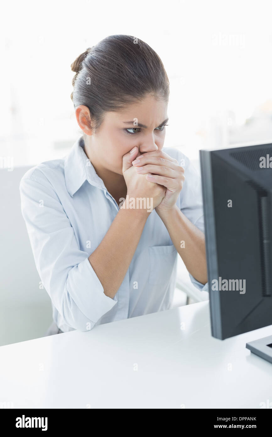 Serious businesswoman looking at computer in office Stock Photo