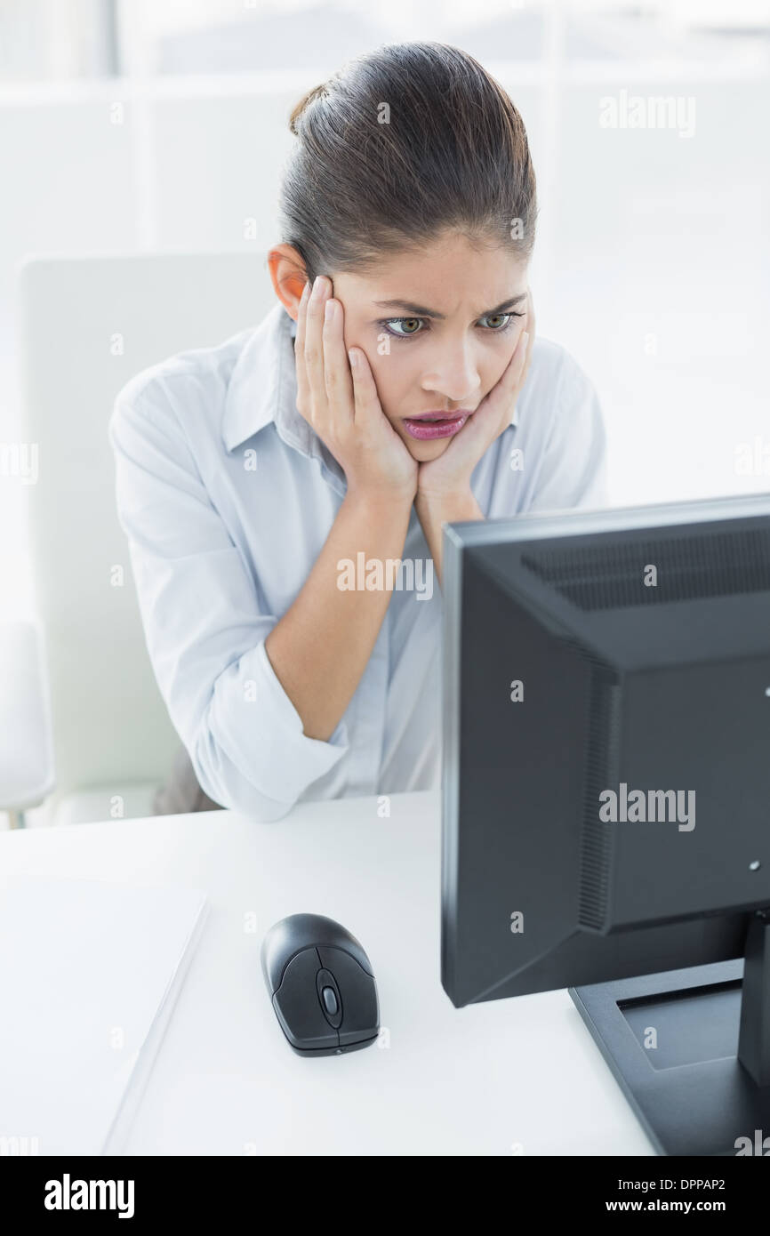 Worried businesswoman looking at computer in office Stock Photo