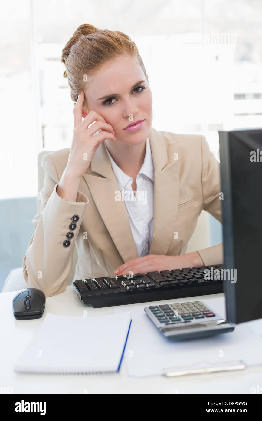 Worried businesswoman with computer at desk Stock Photo