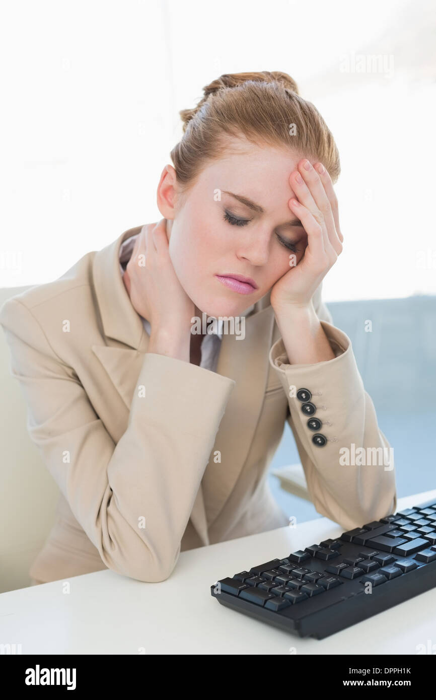 Businesswoman with neck pain at office desk Stock Photo Alamy