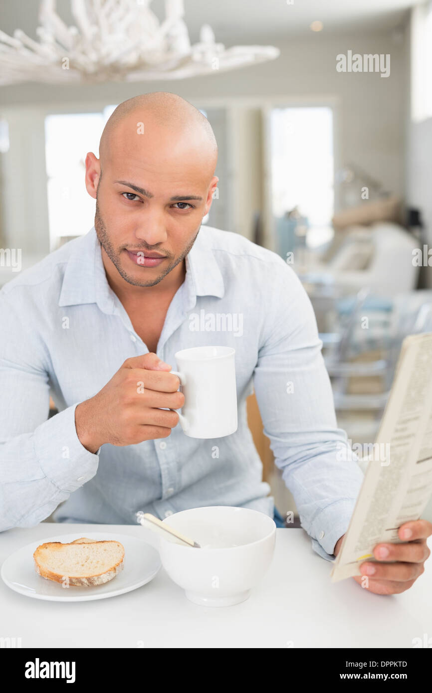 Man drinking coffee while reading newspaper at home Stock Photo Alamy