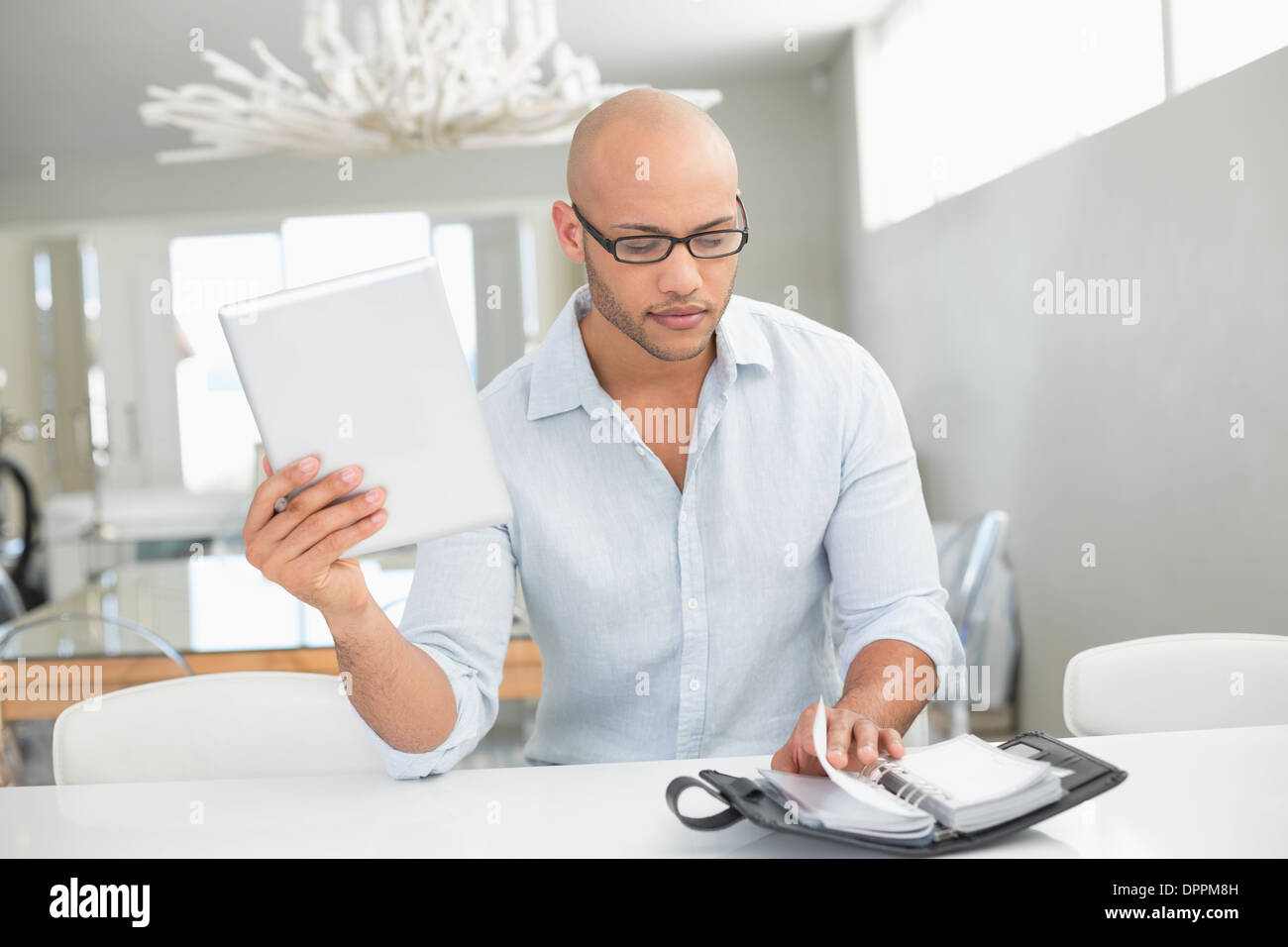 Casual man with digital tablet and diary at home Stock Photo
