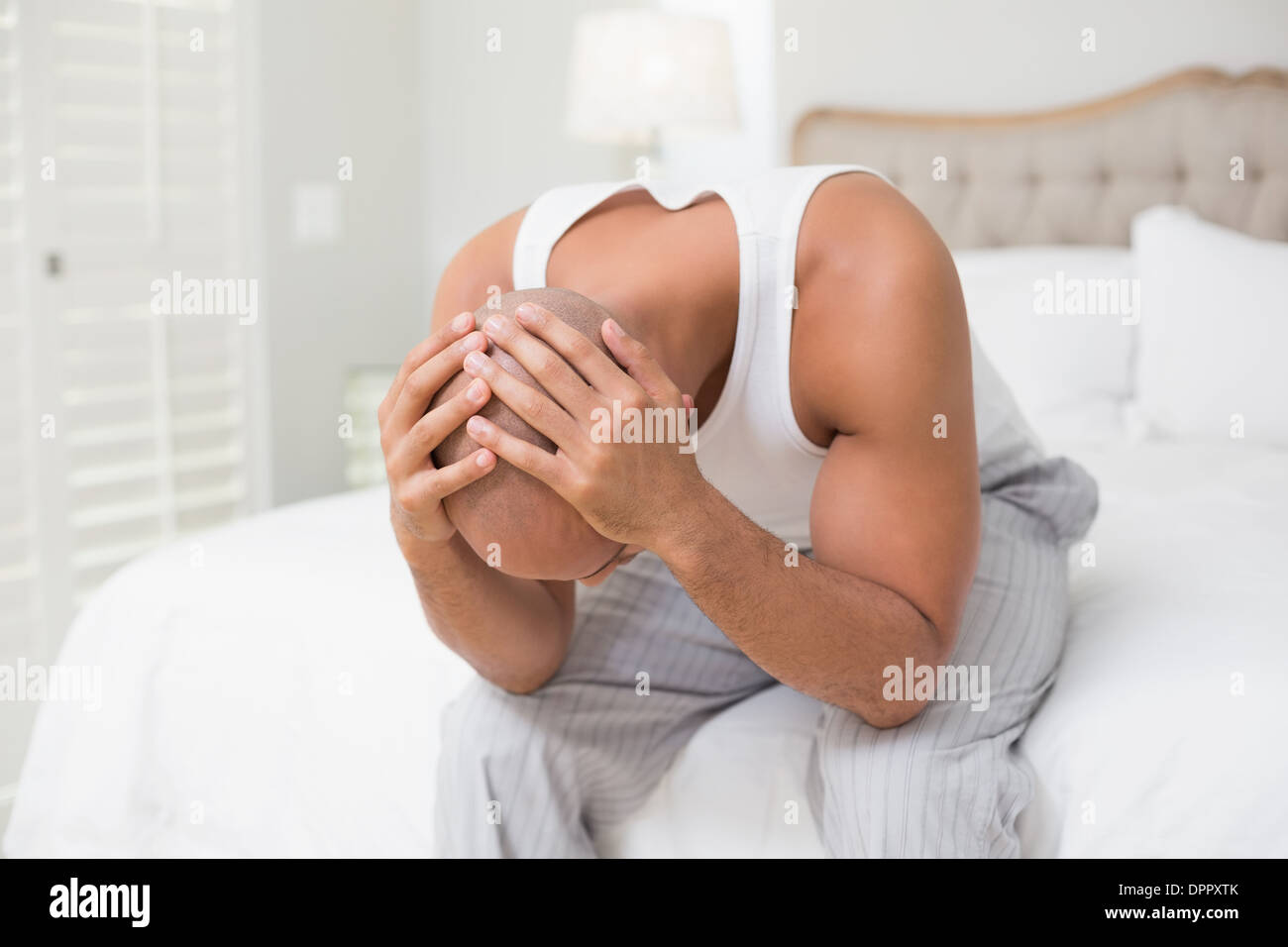 Thoughtful bald man with head in hands on bed Stock Photo Alamy