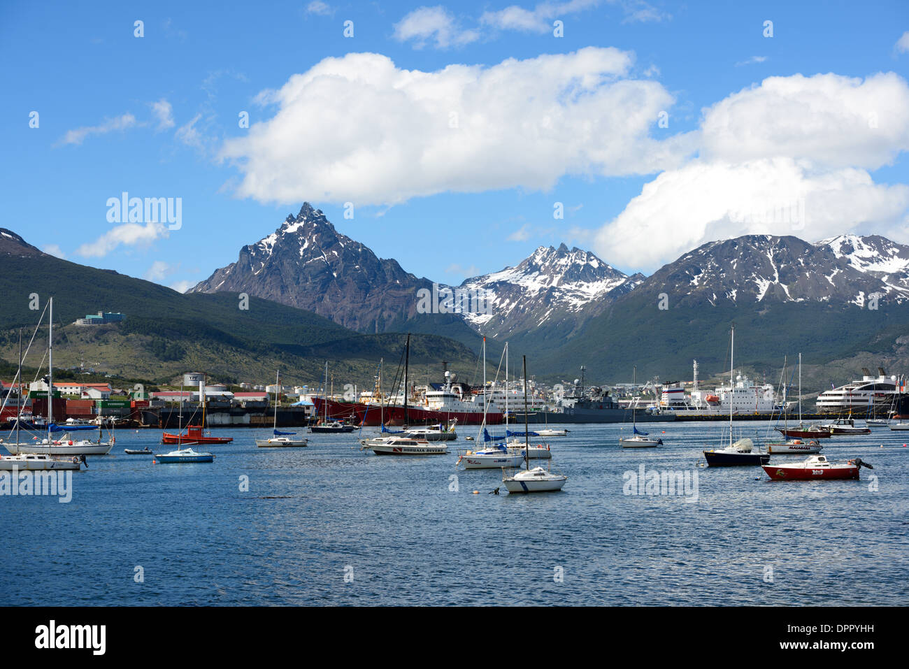 USHUAIA, Argentina - A view of Ushuaia Port from across the harbor, with the distinctive, sharp triangle-shaped Monte Olivia (Mount Olivia) in the background. Nestled at the southern tip of South America, Ushuaia is known as the southernmost city in the world. Overlooking the Beagle Channel and surrounded by the snow-capped Martial Mountains, this unique location serves as a gateway to Antarctica, attracting adventurers from all over the globe. Stock Photo