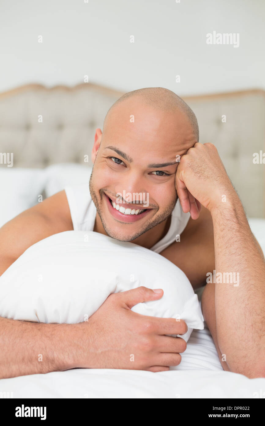 smiling-casual-bald-young-man-lying-in-bed-stock-photo-alamy