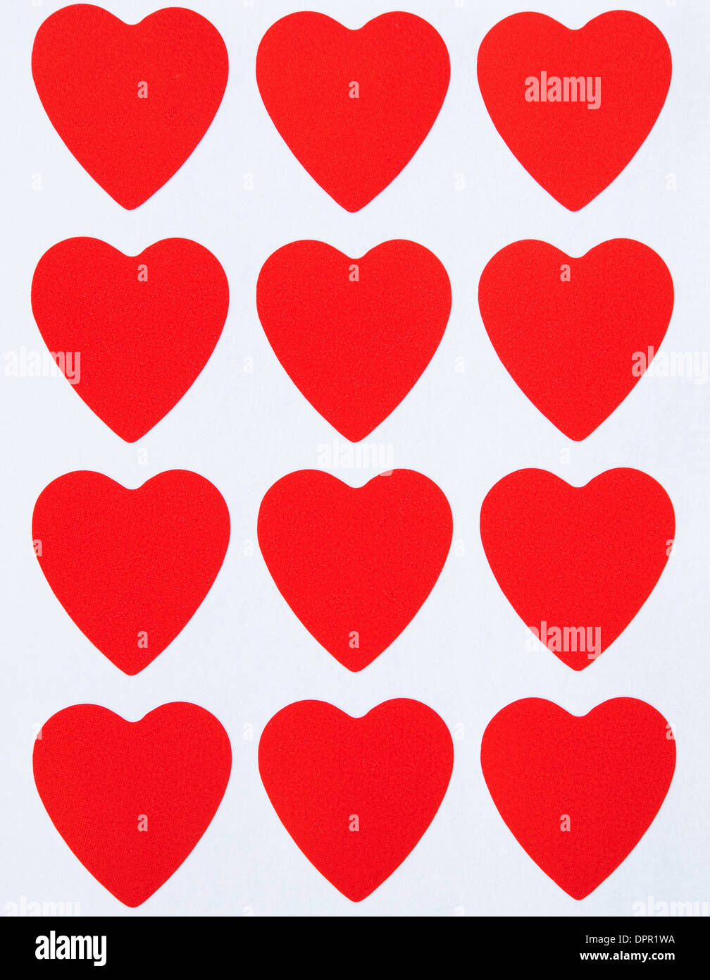 dozen of red hearts on the paper as background Stock Photo