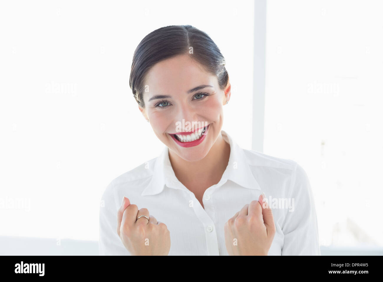 Excited young business woman clenched fists Stock Photo