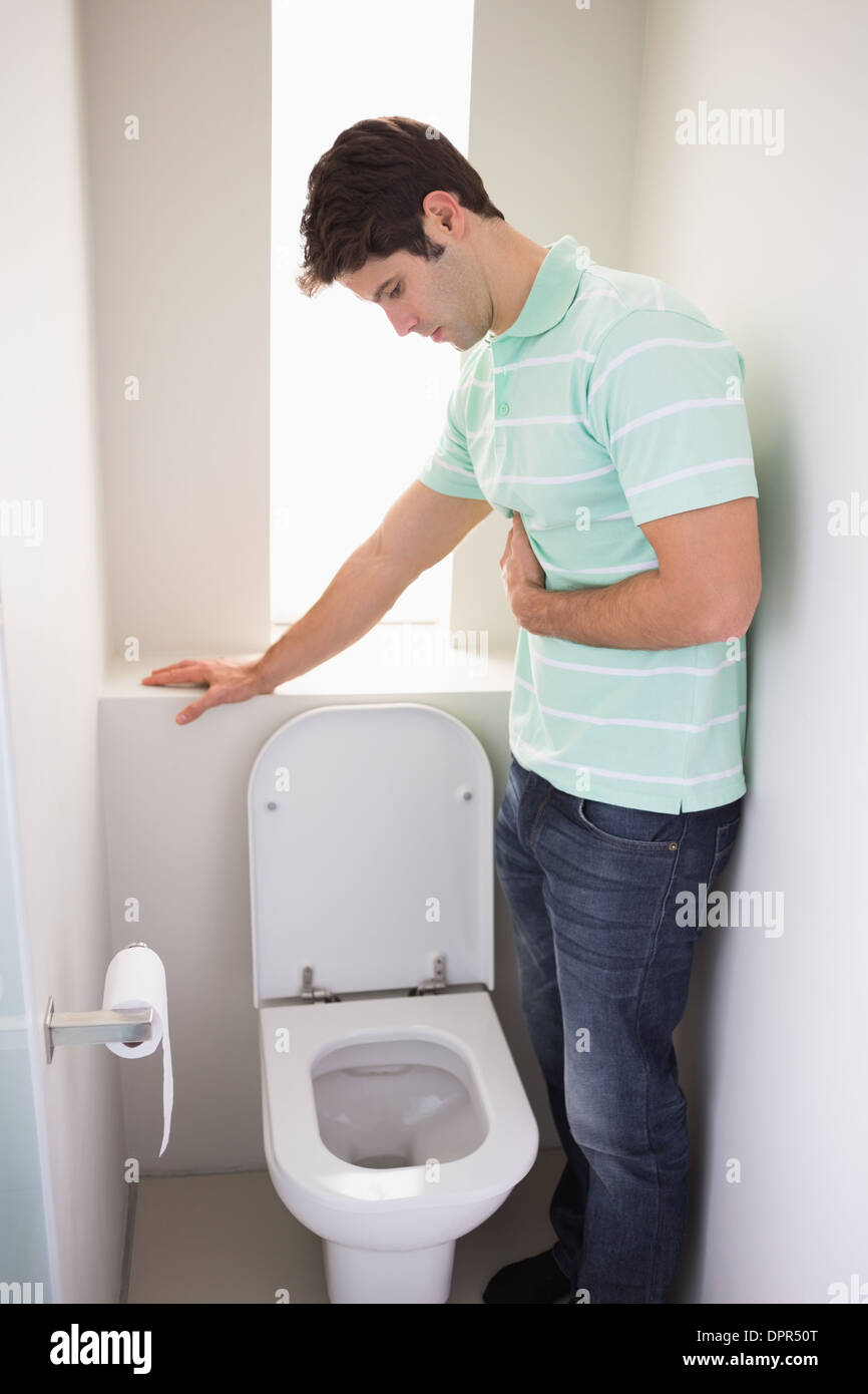 Man with stomach sickness about to vomit into the toilet Stock Photo