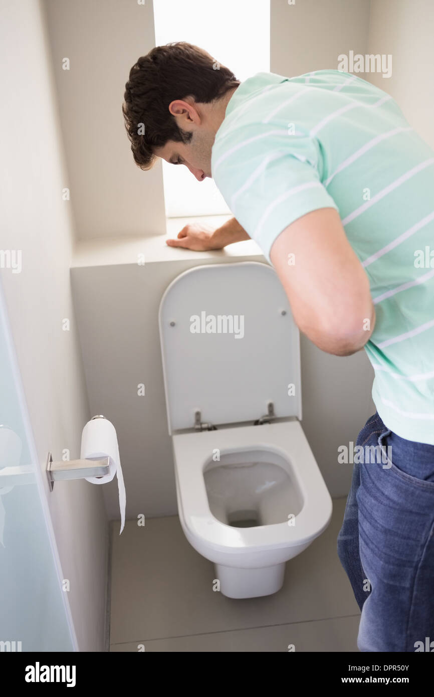 Man with stomach sickness about to vomit into the toilet Stock Photo