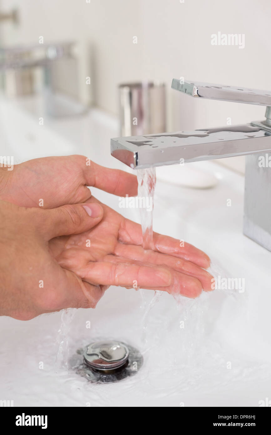 Washing hands under running water at bathroom sink Stock Photo - Alamy