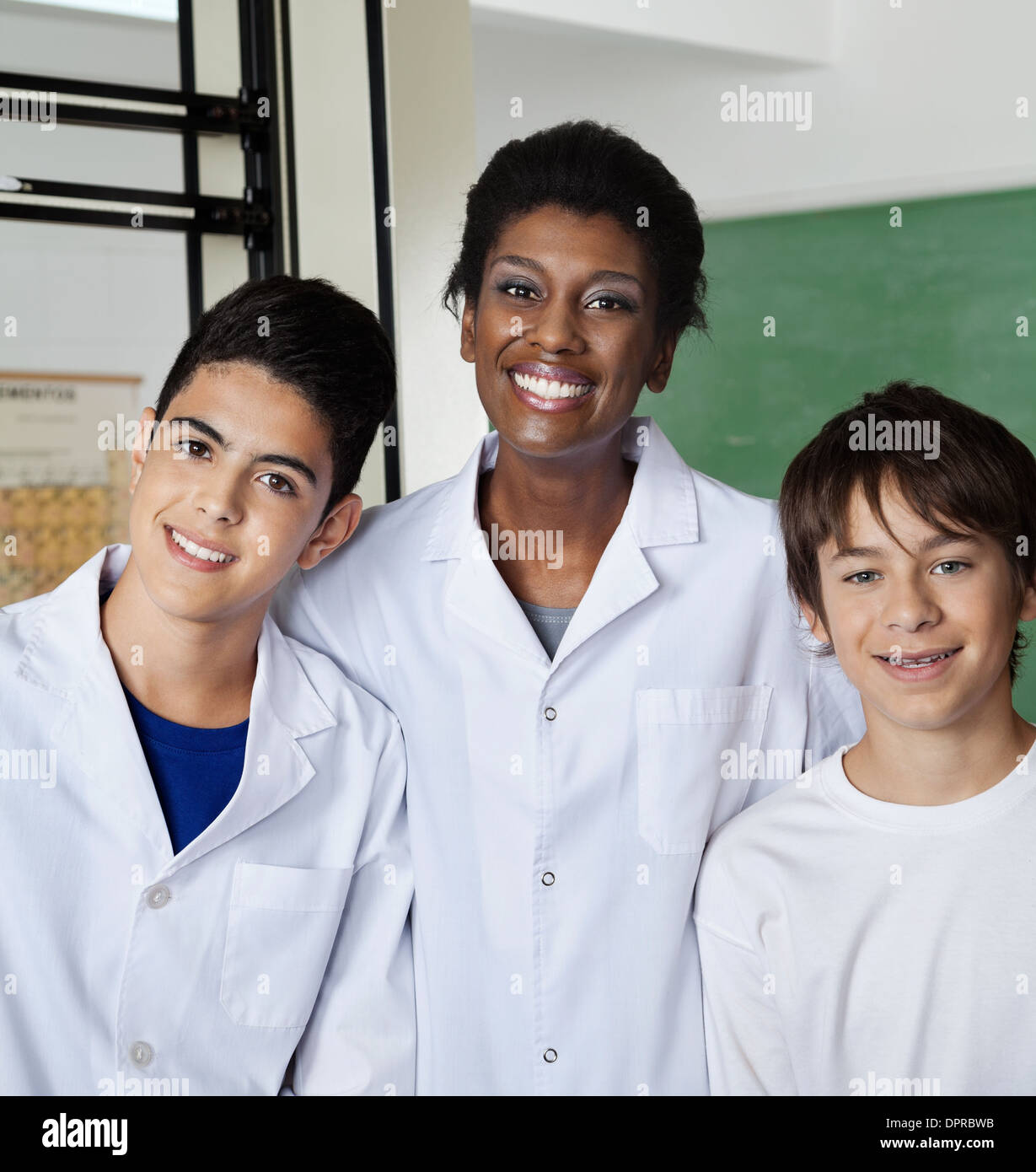 Teacher Standing With Male Students In Lab Stock Photo