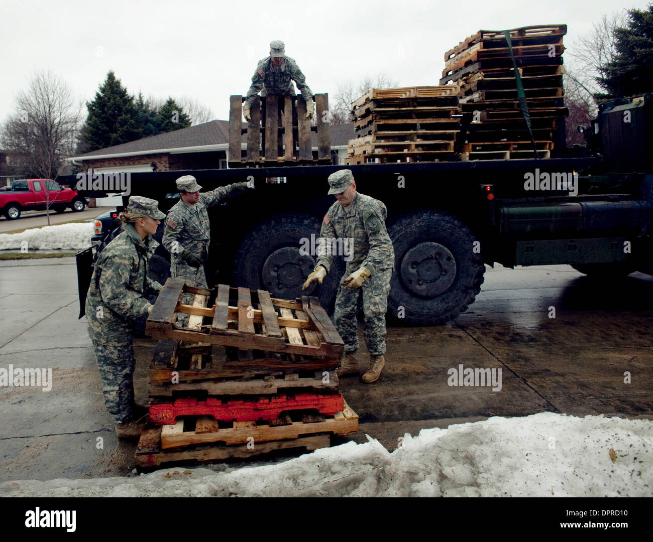 Mar 23, 2009 - Fargo, North Dakota, USA - North Dakota Army National Guard troops haul away empty palettes from River Shore Drive. High schools and universities in the Fargo-Moorhead area canceled classes and encouraged students to help with the flood fighting efforts. The Red River along the North Dakota and Minnesota border is expected to crest at or near record levels in the com Stock Photo