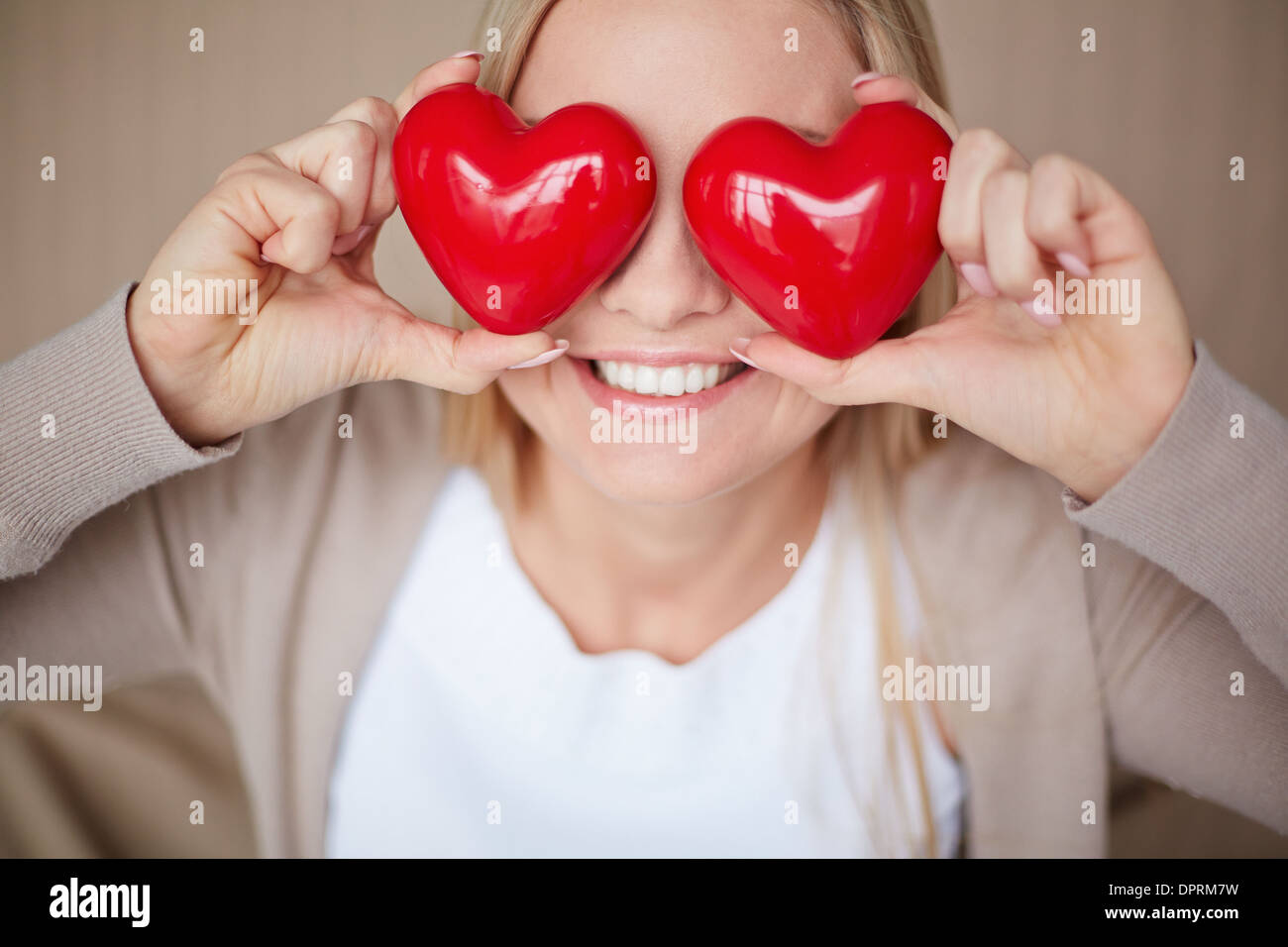 Image of smiling female with two red hearts by her eyes Stock Photo