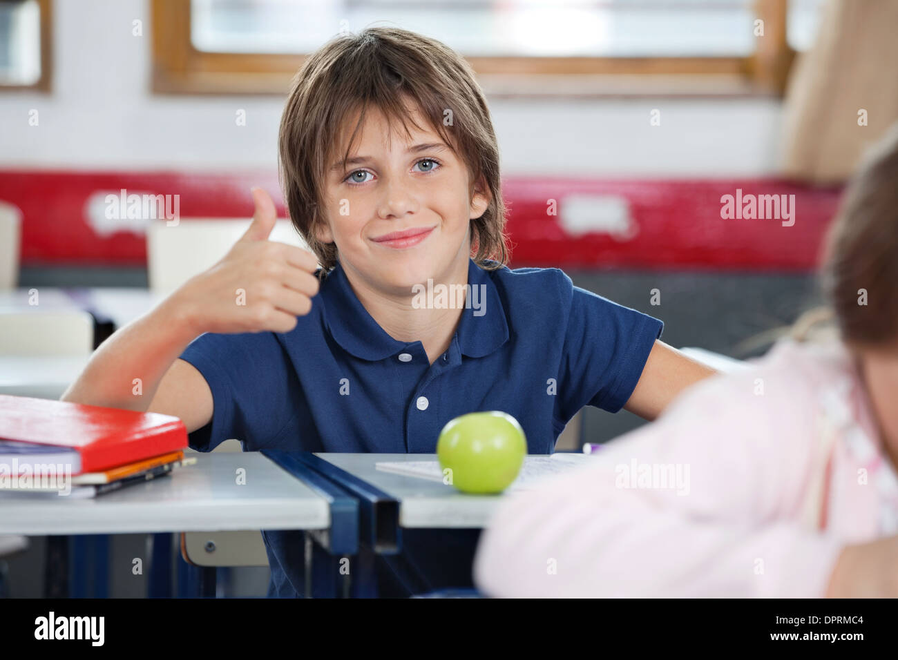Boy Gesturing Thumbs Up In Classroom Stock Photo - Alamy