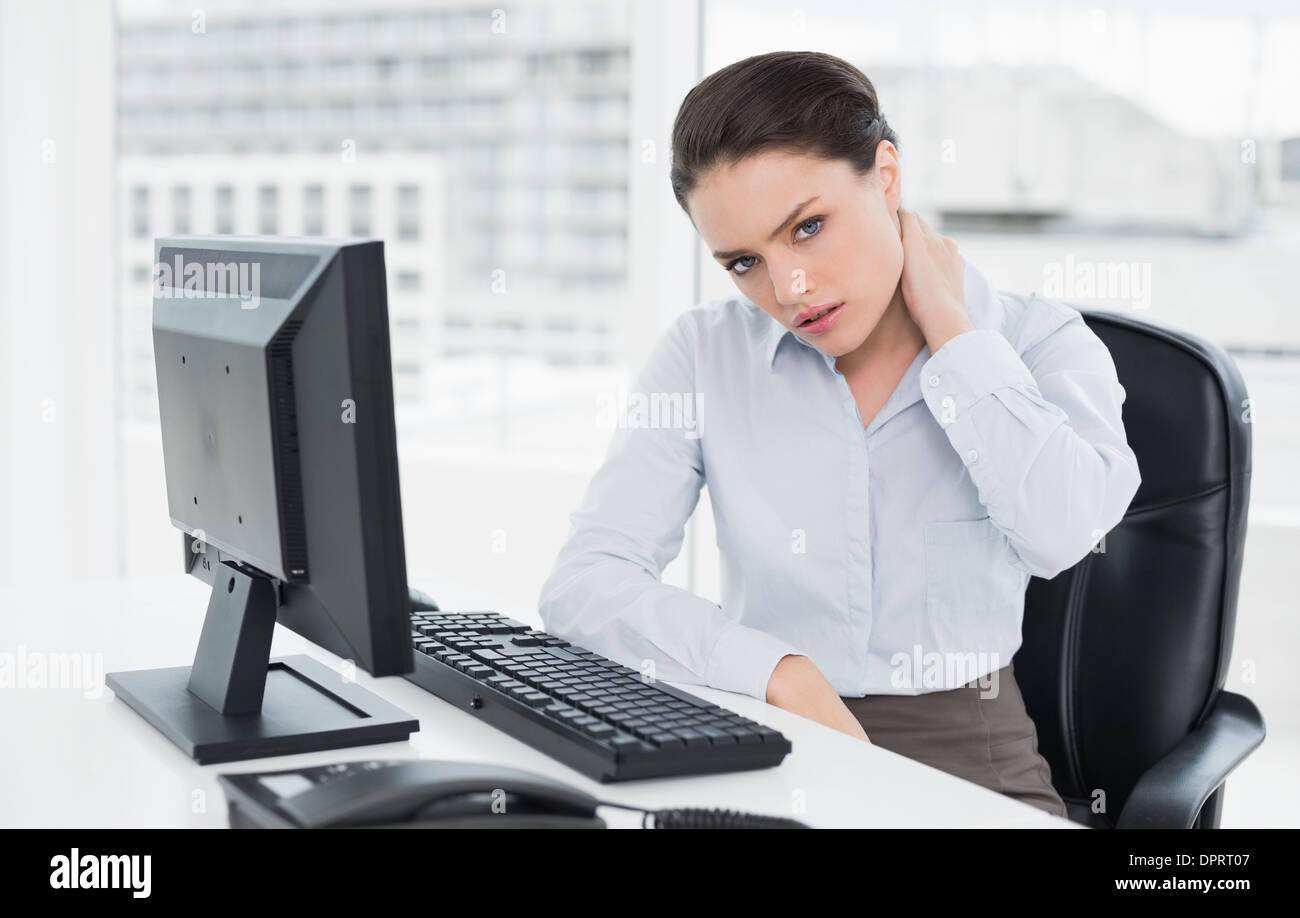 Businesswoman with neck pain sitting at office Stock Photo Alamy