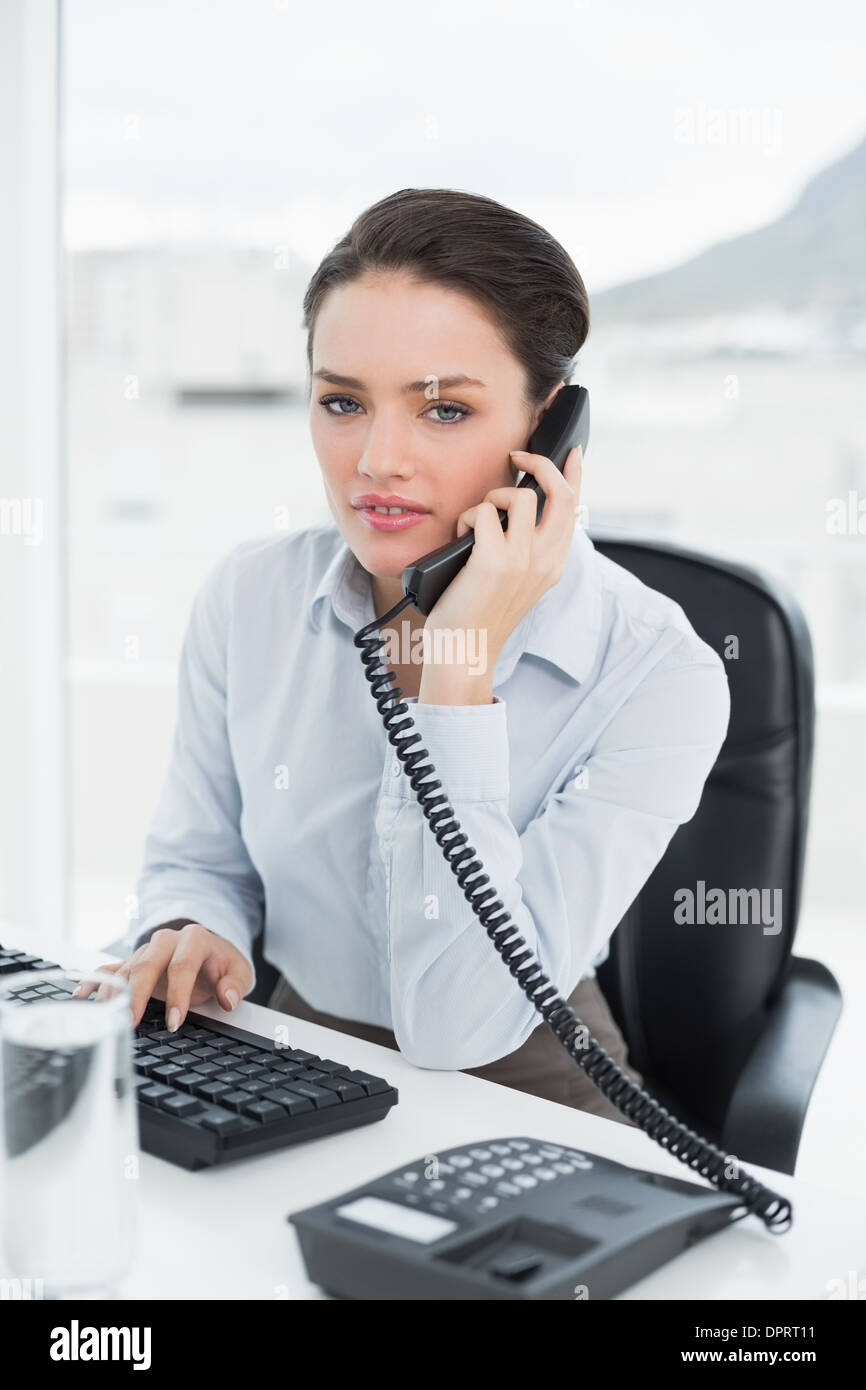 Businesswoman using landline phone at office desk Stock Photo Alamy
