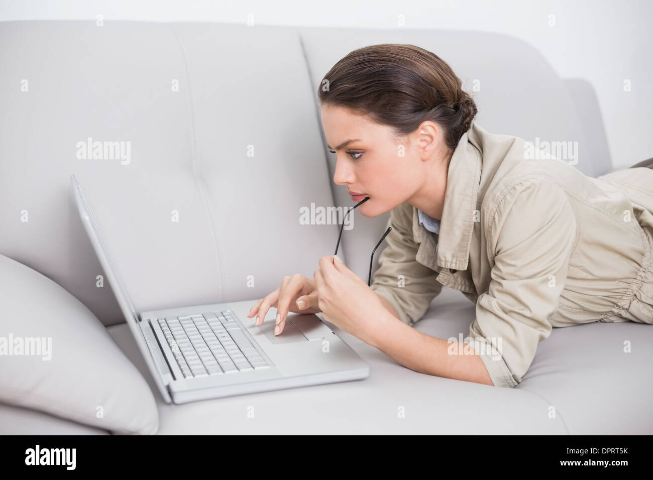 Beautiful woman using laptop on sofa at home Stock Photo - Alamy