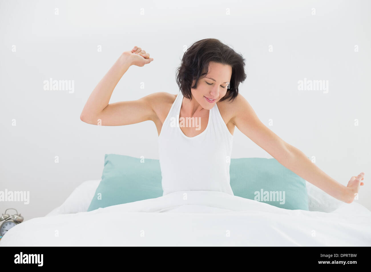Young woman stretching arms in bed Stock Photo Alamy