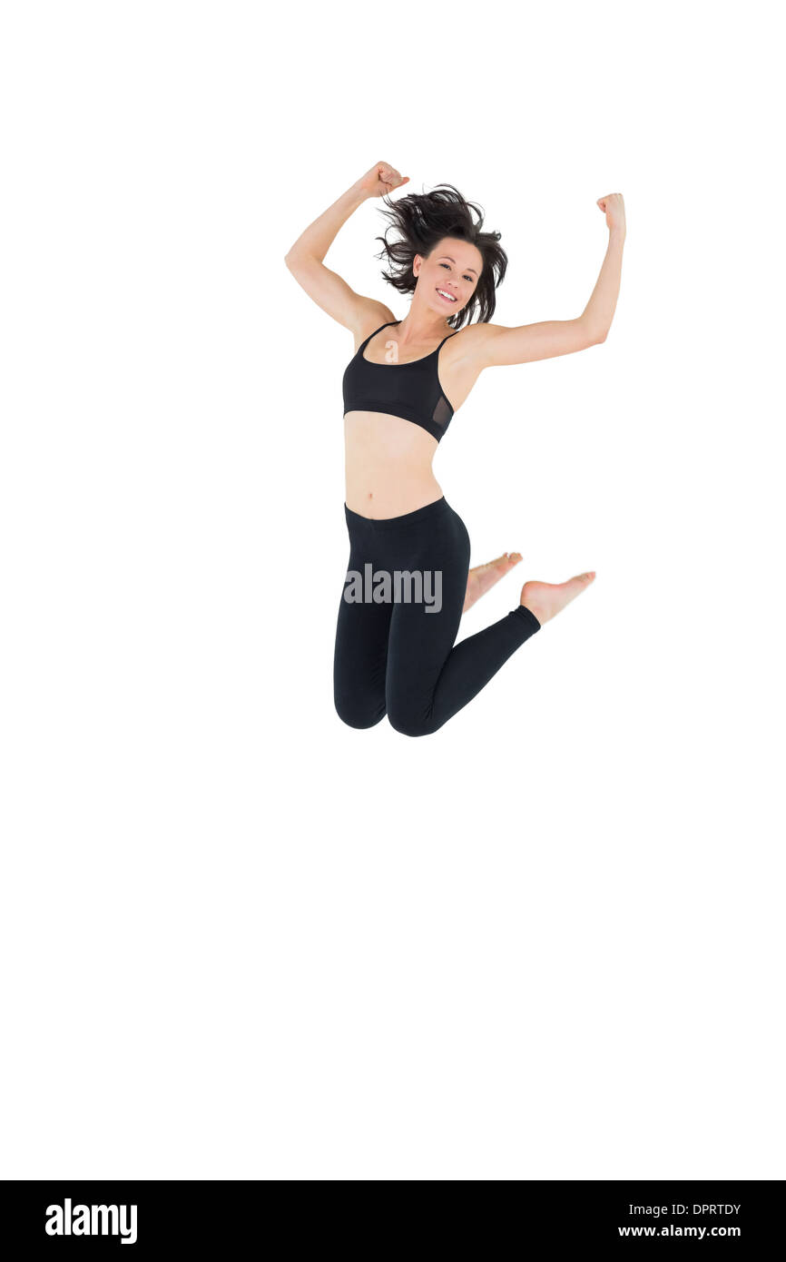 Sporty young woman jumping over white background Stock Photo - Alamy
