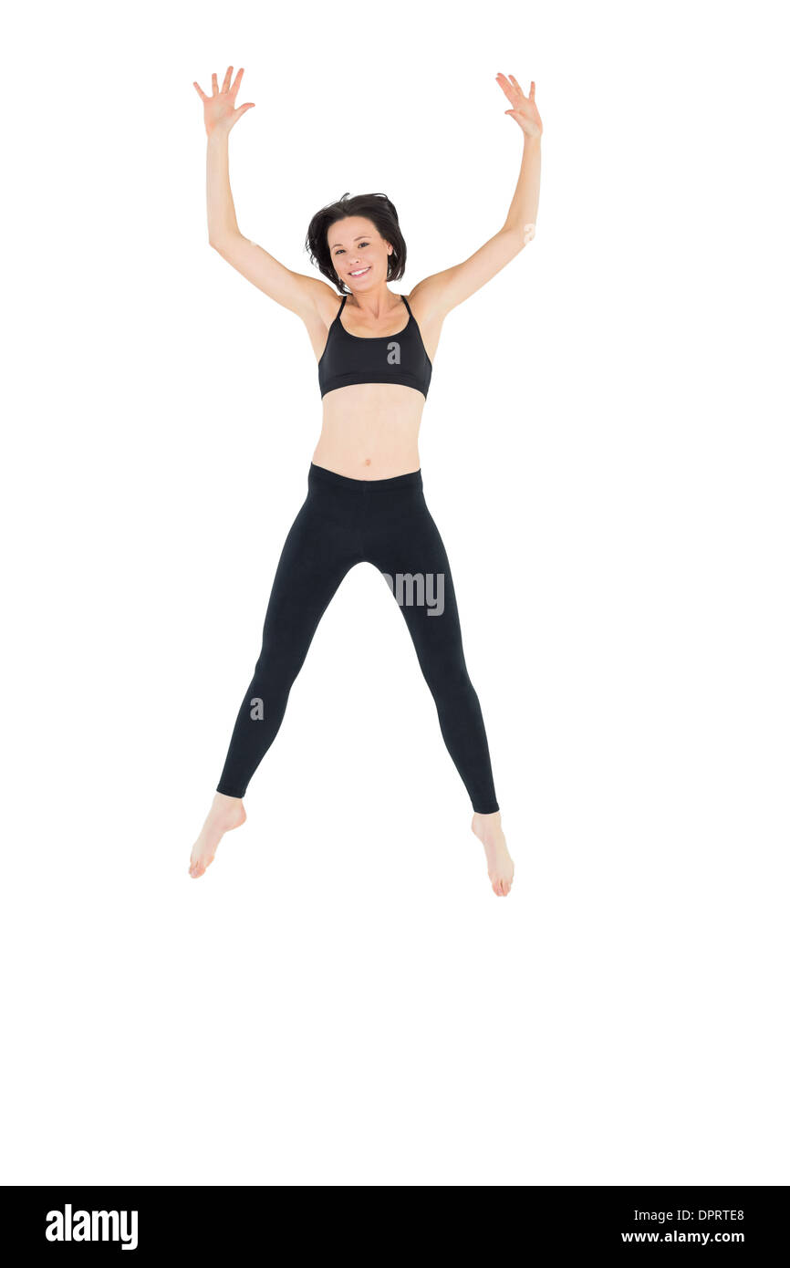 Sporty young woman jumping over white background Stock Photo - Alamy