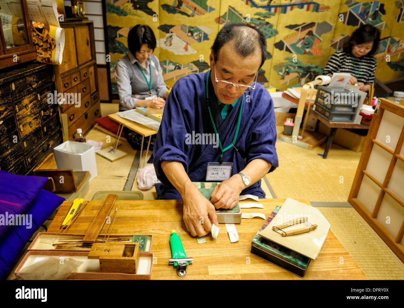 Skilled Japanese craftsman prepares layers of gold ready to make gold leaf, an old Japanese tradition. Kinpaku Kanazawa Japan Craftsman craft Stock Photo