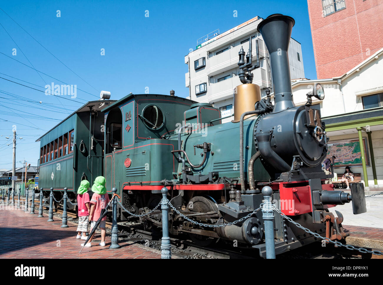 Children look at the machinery of a small, cute steam engine. Please click for full info. Stock Photo