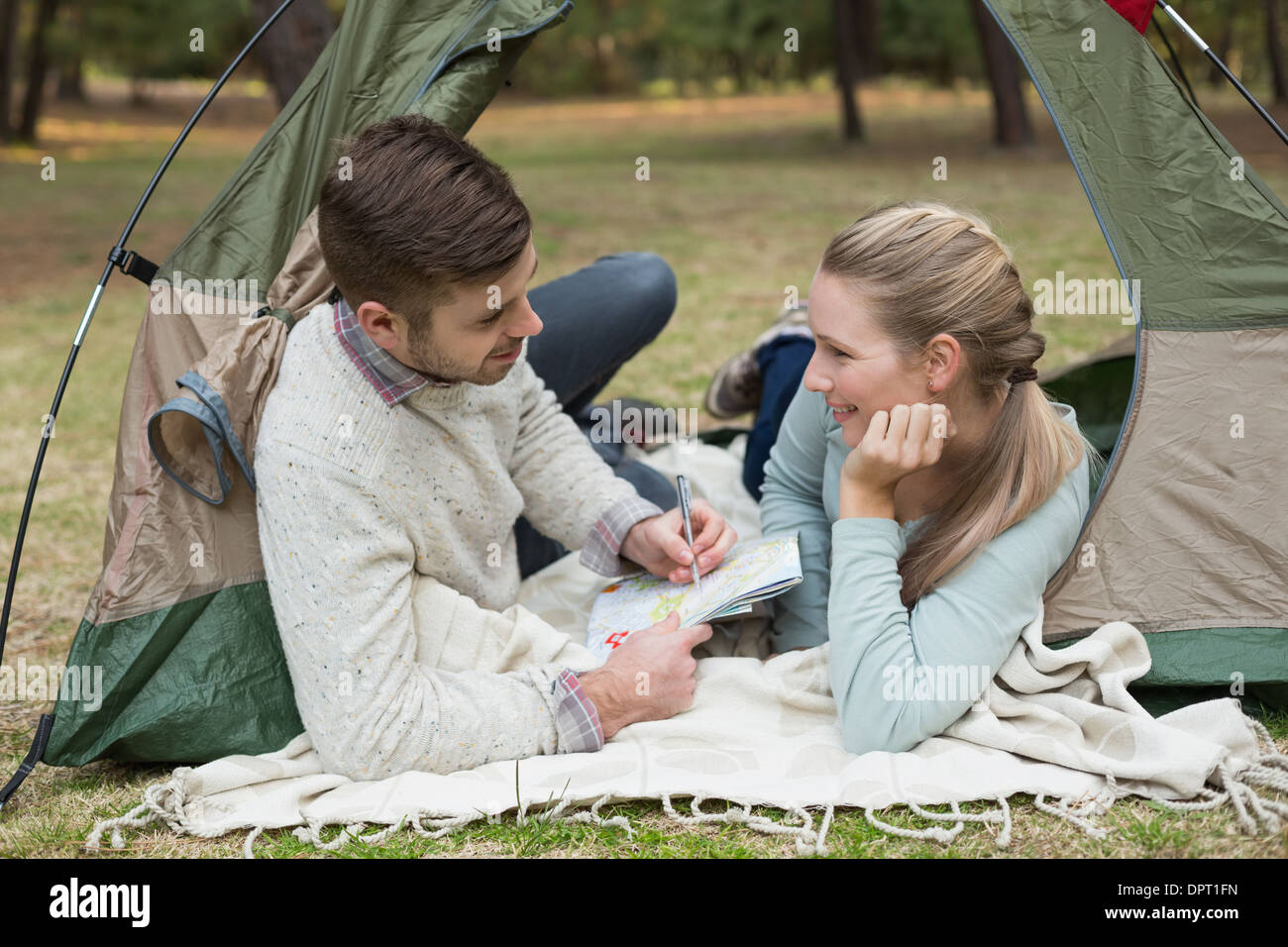 Couple with a map lying in tent Stock Photo