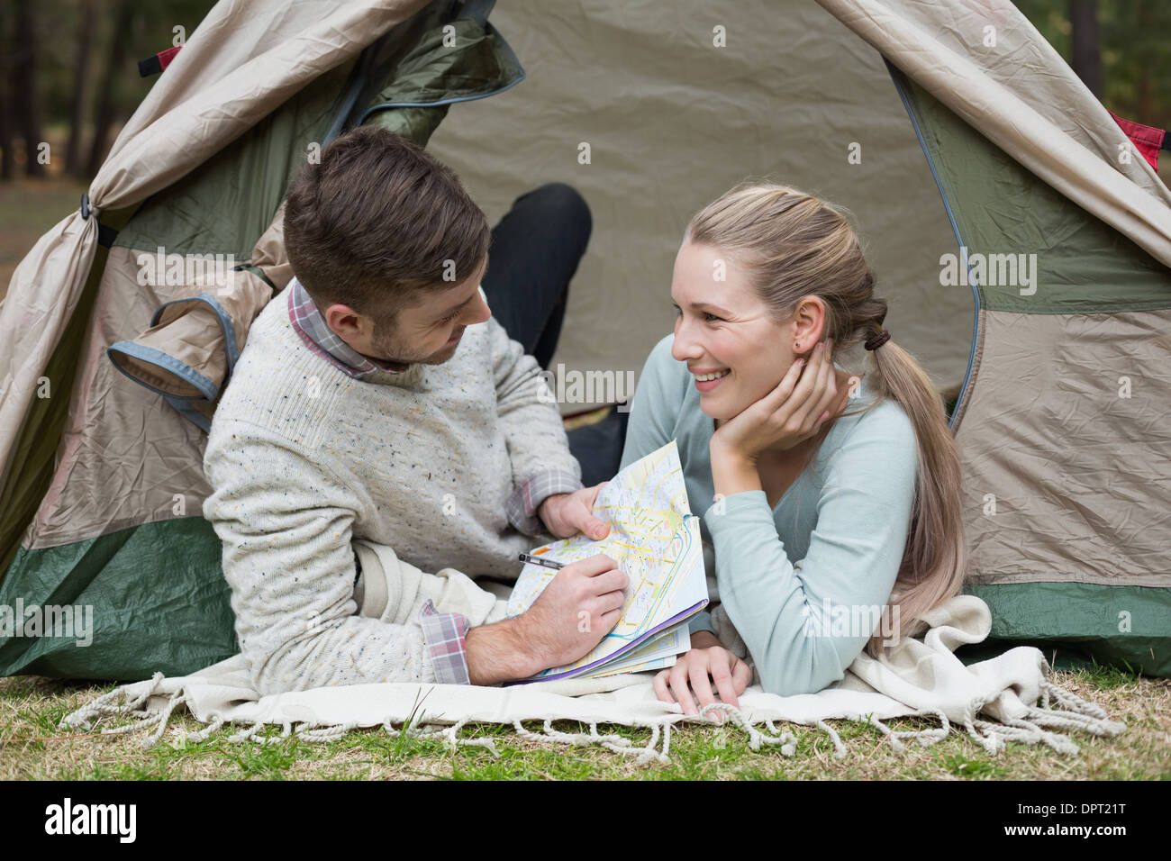 Young couple lying in tent with a map Stock Photo