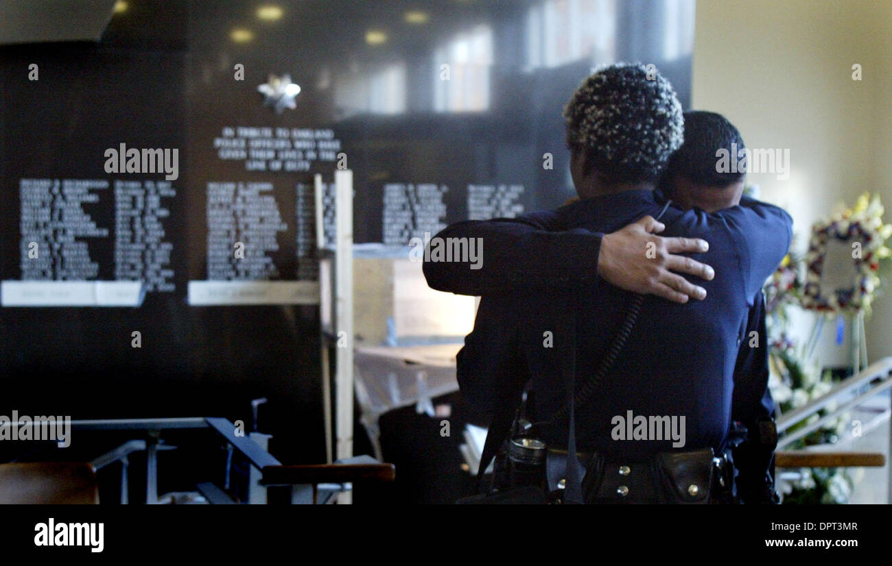 Two Oakland Police officers embrace in the lobby where the Marin Monument Co. is  sandblasting the names of the four officers on the black granite wall at the Oakland Police Department in Oakland, Calif. on Thursday, March 26, 2009. (Laura A. Oda/Staff) Stock Photo