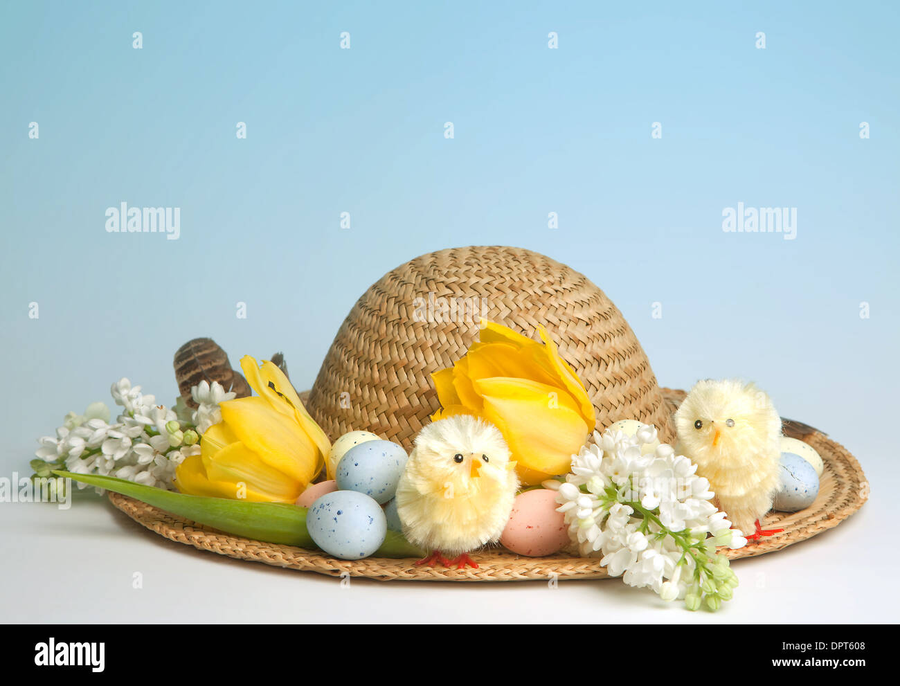 Straw hat decorated for easter with flowers, chicks and easter eggs