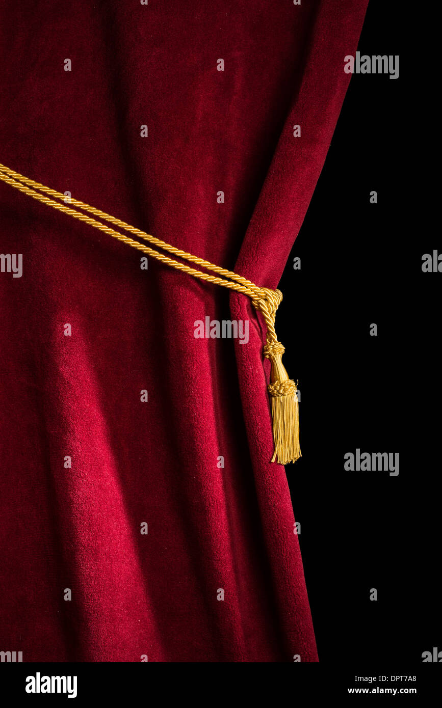 Red velvet curtain with tassel. Close up black isolated curtain Stock Photo