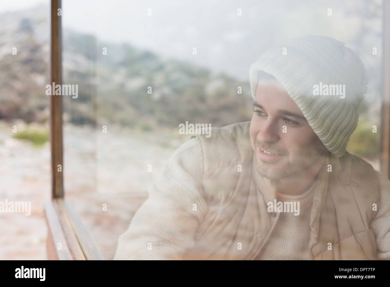 Thoughtful man looking out through window Stock Photo