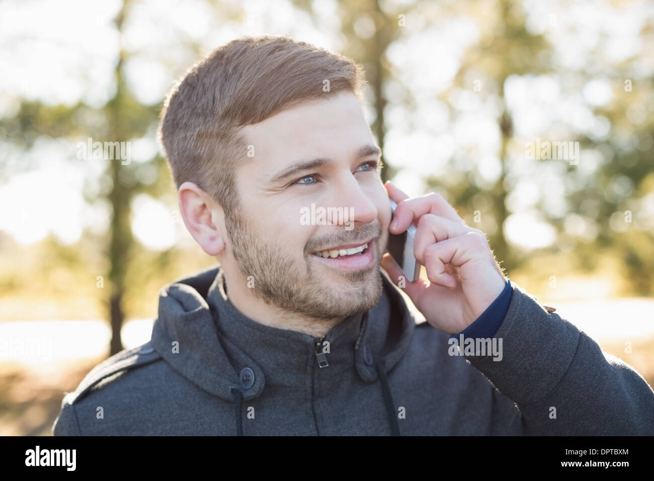 Close up of a smiling man using cellphone outdoors Stock Photo