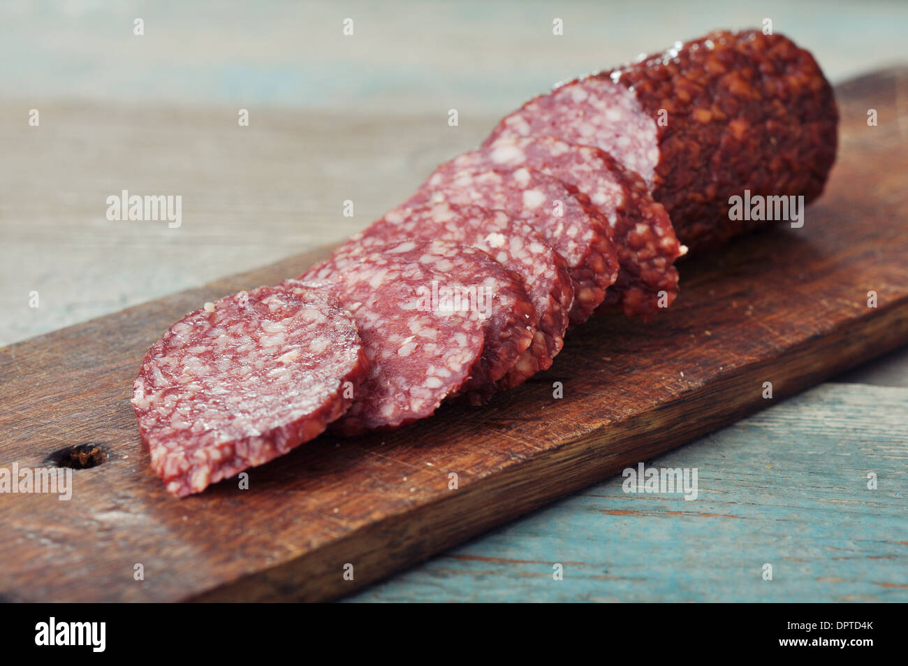 Sliced salami on wooden cutting board closeup Stock Photo